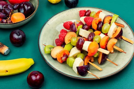 Colorful fruit skewers made from fresh fruits on wooden skewers.
