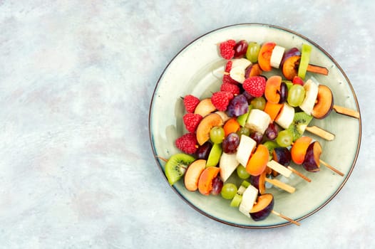 Colorful fruit skewers made from fresh fruits on wooden skewers.