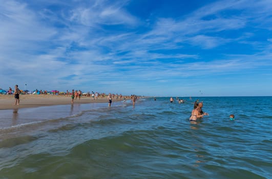 Tavira, Portugal - August 15, 2023: People at the famous beach of Tavira island in Tavira. This beach is a part of famous tourist region of Algarve.