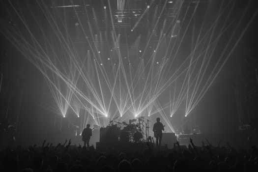 A group of people stands on top of a stage, bathed in a warm, glowing light, creating a vibrant and dynamic atmosphere.