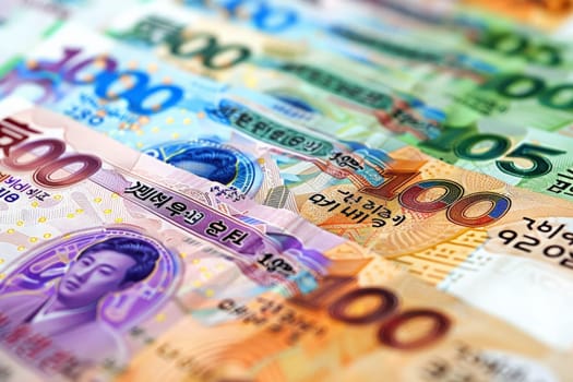 An assortment of South Korean Won currency notes spread out, showcasing vivid designs and values.