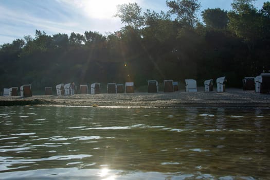 View of beach chairs on the sandy beach from the water of the Baltic Sea, on Poel, Germany