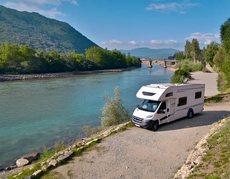 RV camper is parked by a stream in a beautiful, quiet valley