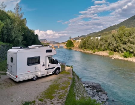 RV camper is parked by a stream in a beautiful, quiet valley