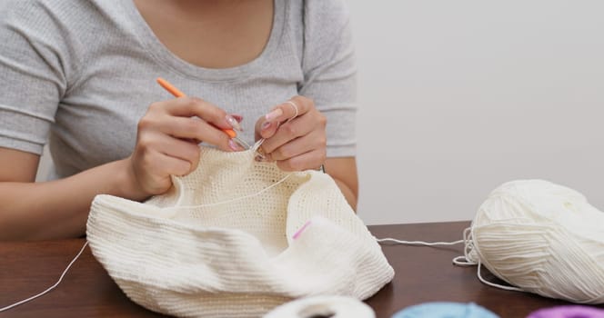 Woman knitter making fabric from thread