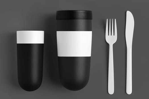 A black and white cup, fork, spoon, and cup arranged in a striking and artistic display.