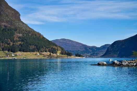 Fjord with mountains on horizon. Water glistens in the sun in Norway. Landscape photo from the north