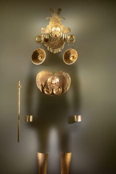 Pre-Columbian gold statuette in the Museo del Oro. Golden indigenous ornament from South American natives civilization. Famous Gold Museum, Bogota, Colombia.