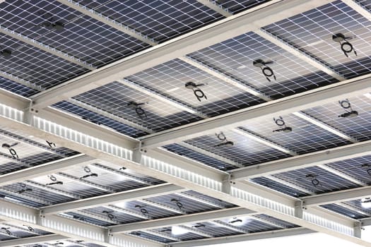 Transparent photovoltaic panels above a parking lot provide shade, rain protection and electricity generation. The facility is nearing completion.