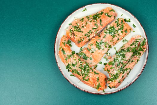 Raw uncooked salmon or trout fillet fish in garlic green marinade. Flat lay