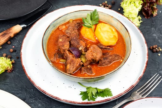 Appetizing goulash made from venison meat, meat goulash or soup with potatoes in a bowl.
