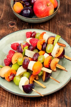 Raw fruit skewers of fresh fruits on wooden skewers. Party healthy snack