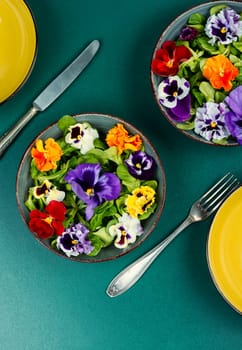 Spring seasonal colorful edible flower salad. Space for text.