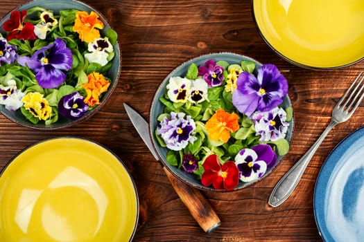Spring seasonal colorful edible flower salad. Space for text.