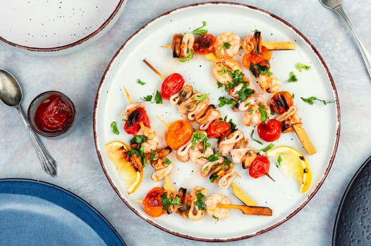 Grilled squid, fried mussels and shrimps on wooden skewers. Seafood appetizers. Flat lay, no people.