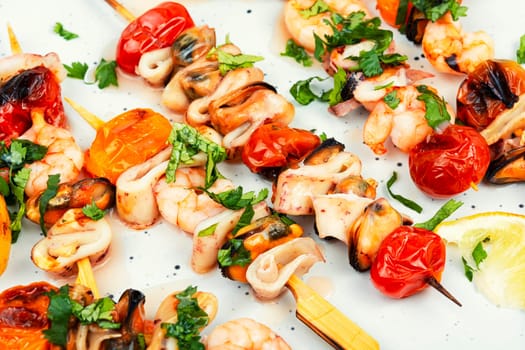 Grilled squid, fried mussels and shrimps on wooden skewers. Seafood appetizers. Flat lay, no people.