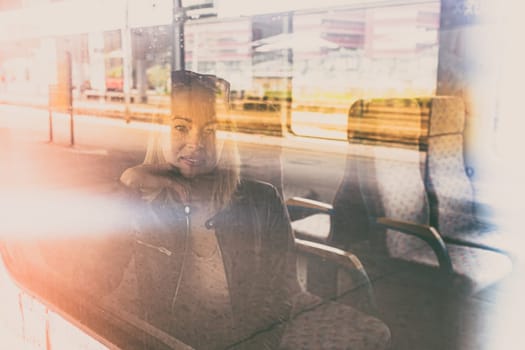 Woman traveler contemplating outdoor view from window of train. Young lady on commute travel to work sitting in bus or train