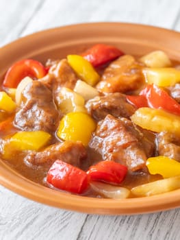 Portion of sweet and sour pork with bell pepper and pineapple