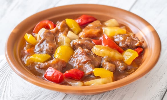 Portion of sweet and sour pork with bell pepper and pineapple