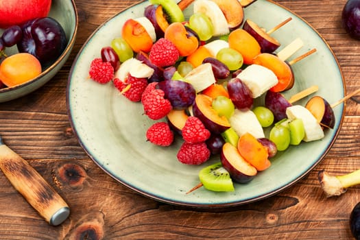 Juicy fruit skewers made from fresh fruits on wooden skewers.