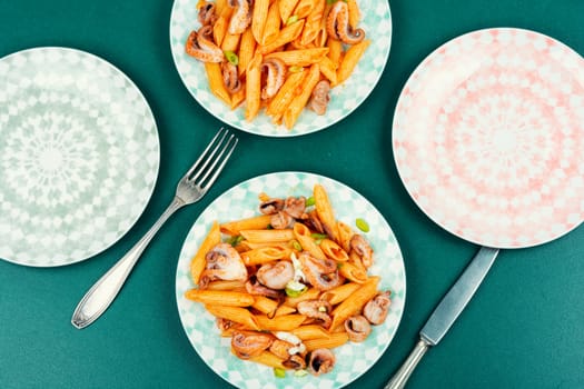 Appetizing macaroni or pasta boiled with octopus. Pasta with seafood. Close up.
