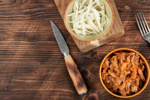 Appetizing stewed cabbage on the old wooden background. Top view, copy space