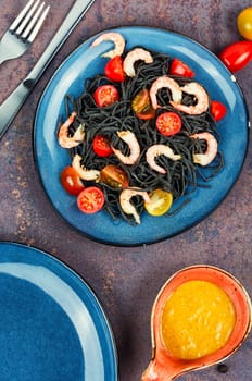 Vegan black bean spaghetti with shrimp and tomatoes. Cooked black pasta spaghetti.
