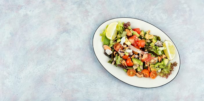 Seafood salad with shrimp, octopus, mussels, tomatoes, avocado and mixed greens. Healthy food.