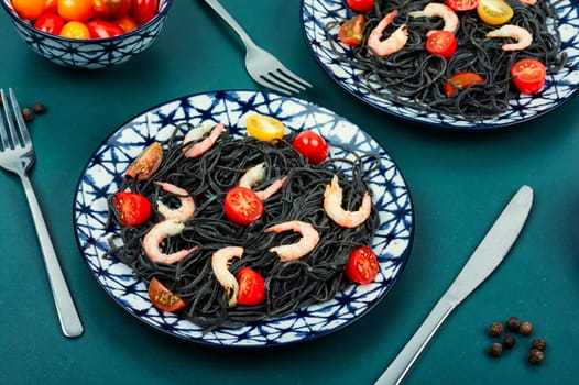 Vegan black bean spaghetti with shrimp and tomatoes. Cooked black pasta spaghetti.