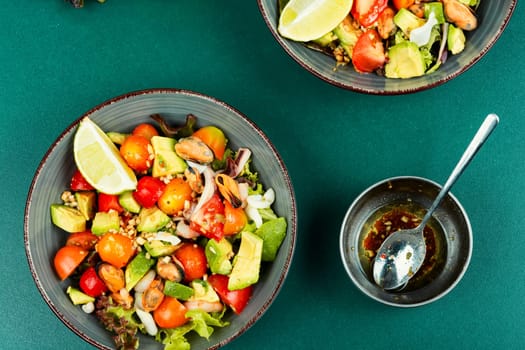 Seafood salad with shrimp, octopus, mussels, tomatoes, avocado and mixed greens. Healthy food.