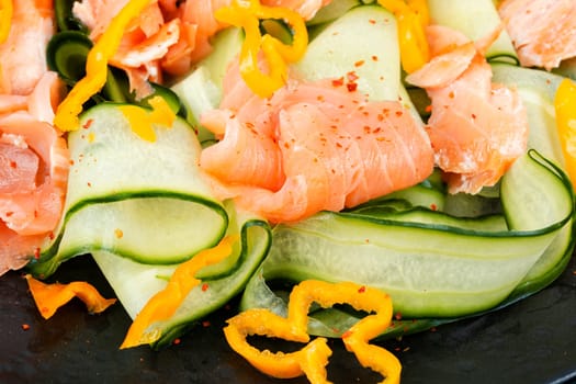 Homemade Asian salad with smoked salmon and fresh cucumber on old rustic wooden table. Flat lay.