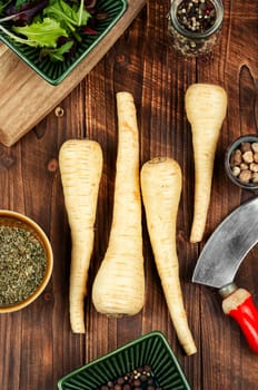 Uncooked parsnips roots on the kitchen table. Fresh vegetable. Top view.