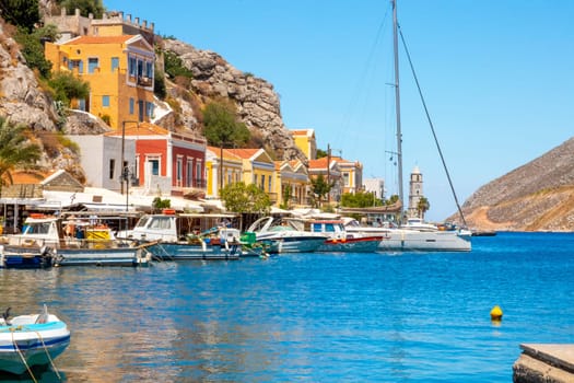 SYMI, Greece - JUN 03, 2021. The harbour of Symi town with the districts of Chorio and Gialos is one of the most beautiful and romantic in the whole Aegean. Colourful mansions stretch up the steep slopes.