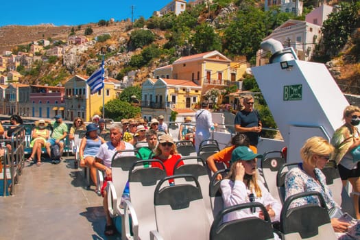 SYMI, Greece - JUN 03, 2021. tourists on board the ship of the Sebeco Lines fleet departing from the port of Symi and heading back to the island of Rhodes. It offers space for 200 passengers.
