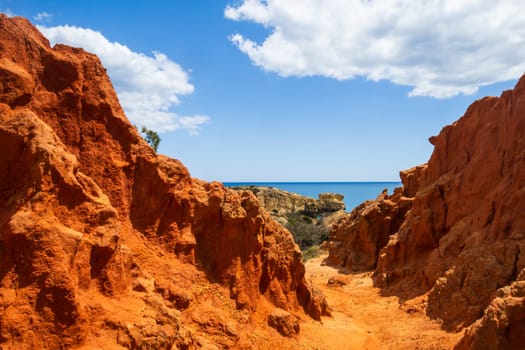 Amazing red sandstone rocks of the coastal cliffs, steep coast near Praia dos Paradinha, Albufeira, Algarve, Portugal