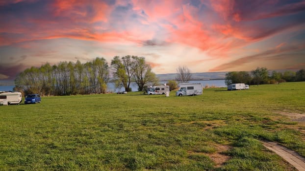 Caravan recreational vehicle at sunrise on the Mediterranean coast in Spain. Camping on the natural beach. Vacation and travel in a mobile home