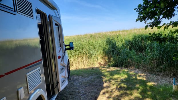 Caravan recreational vehicle at sunrise in Urk Holland. Camping on the natural beach. Vacation and travel in a mobile home