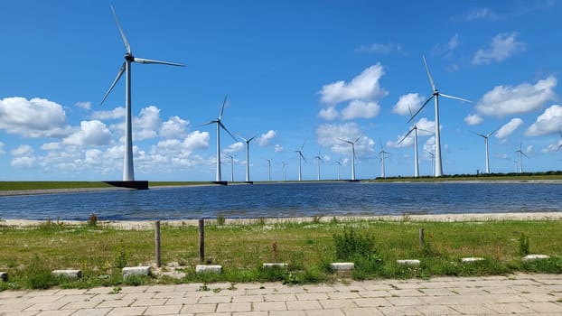 Offshore windmill farm in the ocean Westermeer wind farm, windmills isolated at sea on a beautiful bright day Netherlands Flevoland Noordoostpolder. Huge windmill turbines