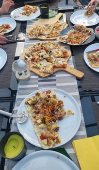 French tarte flambee with cream cheese, bacon and onions. Flammkuchen from Alsace region. Dark background. Top view