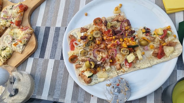 French tarte flambee with cream cheese, bacon and onions. Flammkuchen from Alsace region. Dark background. Top view