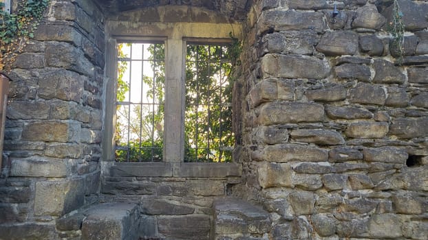Castle window of the Isenburg castle ruins in Essen with bars and green ivy climbing the walls