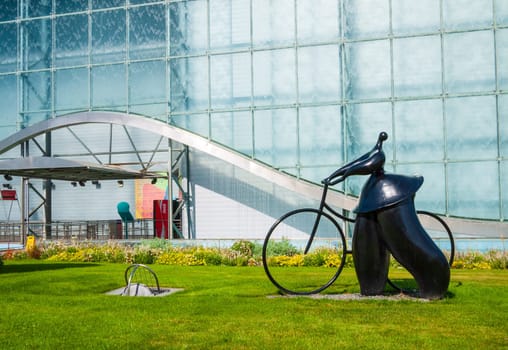 Poitiers, France - September 18 2010 : Pavillon de la Vienne, dynamic movie theatre, sculpture of cyclist from Jean-Louis Toutain in Futuroscope theme park in Poitiers, France