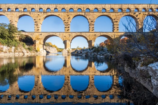 The Pont du Gard over Gardon river. Ancient Roman three-tiered aqueduct bridge. Photography taken in Vers-Pont-du-Gard, Provence, southern France