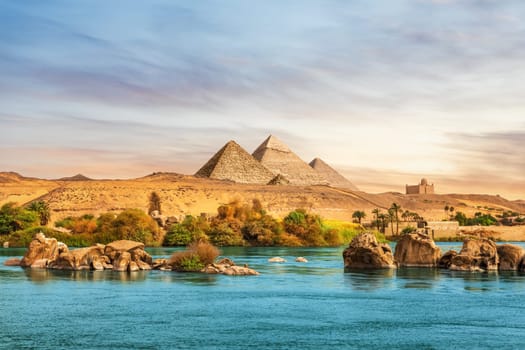 The Nile river and ancient rocks in the Aswan desert by the pyramids, Egypt.