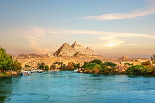 View on the Nile and the boats at sunset in the Aswan desert near the Pypamids of Egypt.