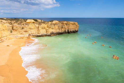 View of cliffs and canoes on ocean, Praia da Ponta Pequena beach near Albufeira, Portugal