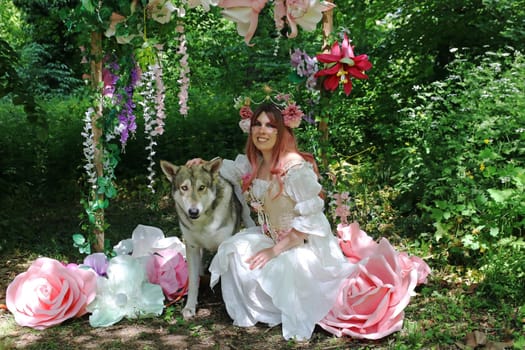 A young laughing woman dressed as a fairy with a wolfhound