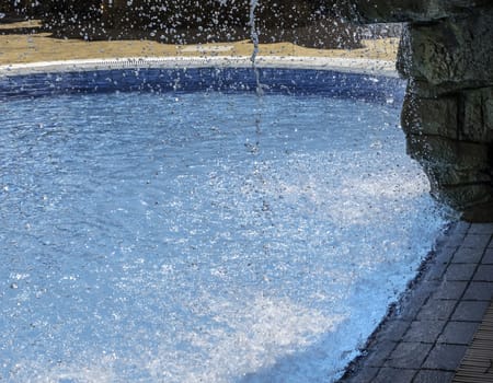 Detail of artificial waterfall in a swimming pool in summer