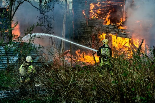 extinguishing the fire of a wooden house. High quality photo
