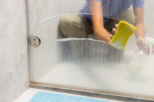 Sponge clean the glass of windows in bathroom